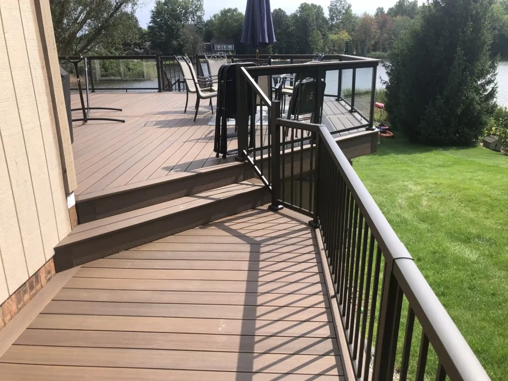 Composite Decking vs Wood Decking - Photo of a Fiberon composite deck with metal railings and glass panels